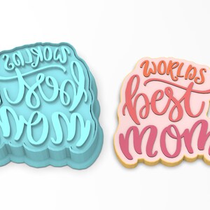 May include: Two cookie cutters, one blue and one pink, with the text "World's Best Mom" and "World's Cool Mom" in a handwritten font.