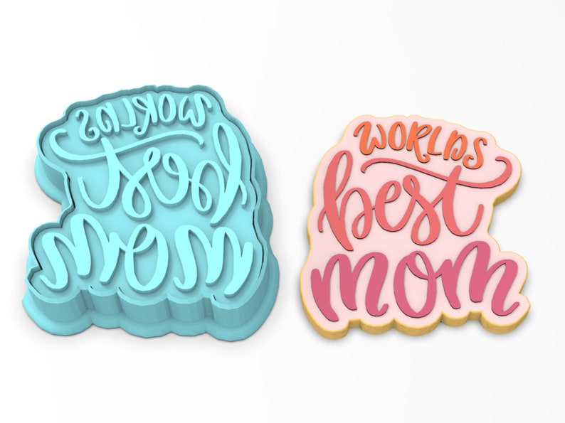 May include: Two cookie cutters, one blue and one pink, with the text "World's Best Mom" and "World's Cool Mom" in a handwritten font.