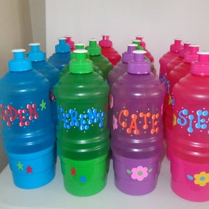 May include: A collection of 10 personalized water bottles with colorful designs and names like "Sienna", "Cate", and "Garden". The bottles are made of clear plastic with a colorful design on the outside.