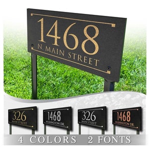 May include: Four different styles of black yard signs with gold, silver, and copper lettering. The signs display house numbers and street names. The text on the signs reads "1468 N. MAIN STREET", "326 MAIN STREET", and "1468 WASHINGTON DR.". The signs are displayed on a green grassy background. The text at the bottom of the image reads "4 COLORS 2 FONTS".
