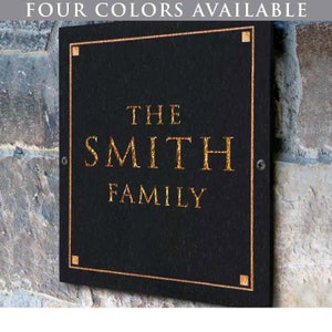 May include: Black rectangular sign with gold lettering that reads "The Smith Family".