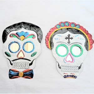 frida and catrin couple, pair of catrina and catrin skulls, frida sugar skull, tin sugar skull, day of the dead, mexican tin folk art
