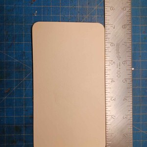 May include: A blank, off-white rectangular card with rounded corners. The card is approximately 6 inches long and 4 inches wide.