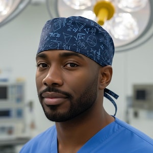 May include: A dark blue scrub cap featuring a repeating white print of mathematical formulas, geometric shapes, and scientific symbols. The cap is designed with a tie-back closure and is constructed from fabric with a fitted, rounded crown.