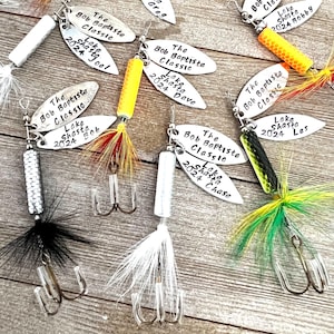 Pu&ograve; includere: Una collezione di sette esche da pesca argentate con piume colorate e un amo triplo. Ogni esca ha un'etichetta argentata con il testo "The Bob Baptiste Classic" e "Lake Shasta" seguito da un anno e un nome.
