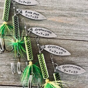 Pu&ograve; includere: Cinque esche da pesca con piume verdi e gialle e un'etichetta di metallo argentato con il testo "Groom 9-7-19", "Best Man 9-7-19", "Groomsman 9-7-19", "Groomsman 9-7-19" e "Groomsman 9-7-19".