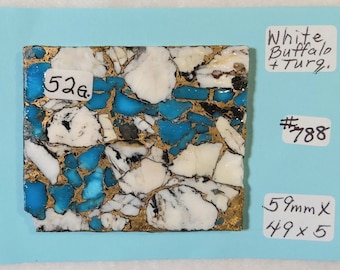 May include: A close-up of a white buffalo turquoise stone with blue and gold veins. The stone weighs 5.2 grams and measures 5.9 cm x 4.9 cm. The stone is labelled "White Buffalo Turquoise #788".