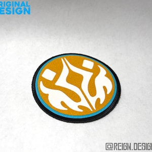 May include: A round, yellow and blue embroidered patch with a white design of two stylized figures with flames. The text "ORIGINAL DESIGN" is visible in the background.