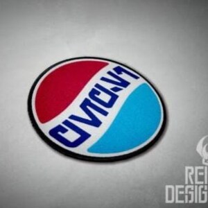 May include: A circular embroidered patch featuring a red upper section and a light blue lower section, separated by a white wavy band. The text "CIVIC V1" is printed in bold blue capital letters across the center, all enclosed by a black border.