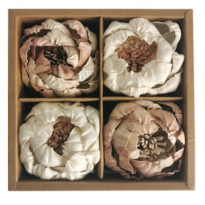 Op de afbeelding: Een vierkante kartonnen doos verdeeld in vier secties, elk met een grote, kunstmatige bloem. Twee bloemen zijn wit en twee zijn een mix van wit en stoffig roze. De bloemen hebben gedetailleerde bloembladstructuren.
