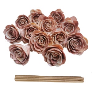 May include: A bunch of 12 small, light brown wooden roses with a natural wood grain. The roses are arranged in a cluster and have a delicate, romantic look. The roses are perfect for adding a touch of rustic charm to any craft project or home decor.