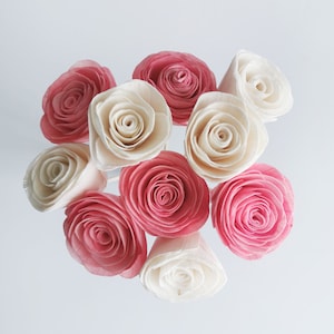May include: A bouquet of artificial flowers with a mix of pink and white roses. The roses are made of wood and have a realistic appearance.