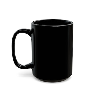 May include: A solid black ceramic coffee mug with a large handle. The mug is cylindrical and has a glossy finish. The mug is empty and sits on a white surface.