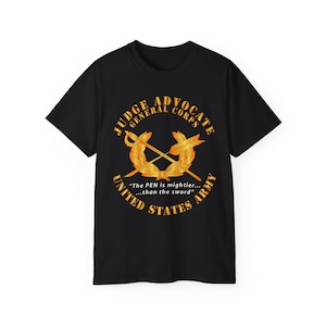 Puede incluir: Camiseta negra con un diseño dorado. El diseño incluye las palabras "Judge Advocate General Corps" y "United States Army", espadas cruzadas y la cita, "The PEN is mightier...than the sword."