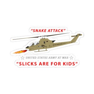 May include: A sticker featuring a tan military helicopter with the text "SNAKE ATTACK" above it and "SLICKS ARE FOR KIDS" below. The words "UNITED STATES ARMY AT WAR" are also present.
