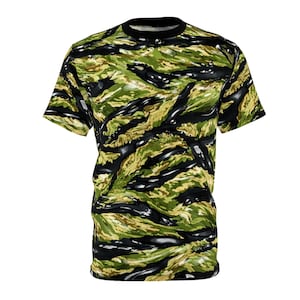 Op de afbeelding: Een t-shirt met korte mouwen met een tijgerstreep camouflagepatroon in groen, zwart en bruin. Het shirt heeft een zwarte ronde hals.