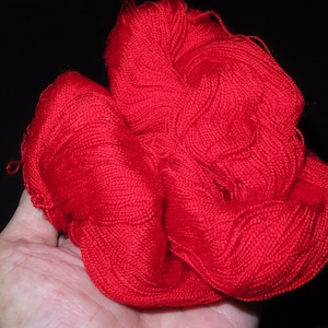 Könnte beinhalten: Eine große Knäuel leuchtend roten Garns, perfekt zum Stricken oder Häkeln.