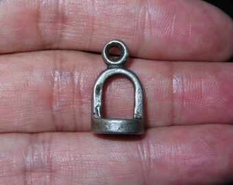 Può includere: Ciondolo in argento con una parte superiore circolare e un'apertura a forma di anello. Il ciondolo è progettato a forma di ferro di cavallo.