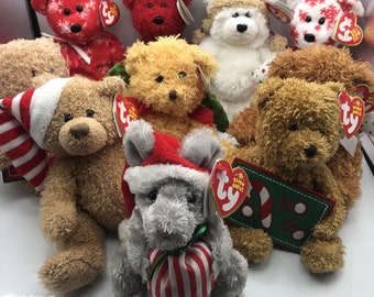 May include: A collection of nine plush Christmas-themed beanie babies. The beanie babies are all wearing Santa hats and have red and white striped scarves. The beanie babies are sitting on a white surface. The beanie babies are all different colours and have different designs. The beanie babies are all holding a Ty Beanie Baby tag.