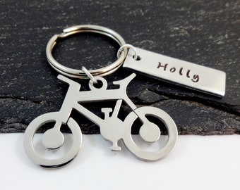 May include: Silver bicycle keychain with a silver tag that says "Holly".
