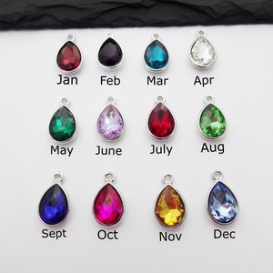 Puede incluir: Doce abalorios de cristal en forma de l&aacute;grima de varios colores, cada uno representando un mes del a&ntilde;o. Los abalorios son plateados y tienen un bucle para sujetarlos a un collar o pulsera.