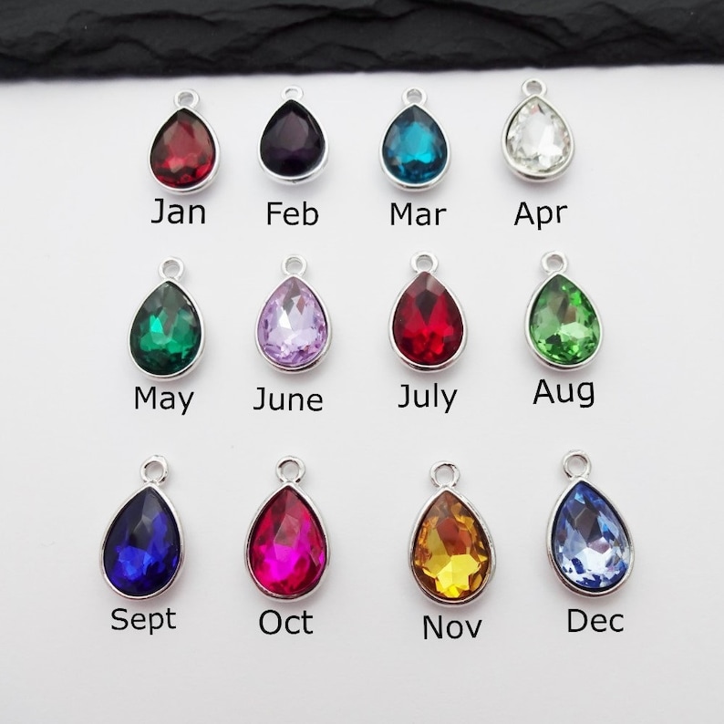 Puede incluir: Doce abalorios de cristal en forma de l&aacute;grima de varios colores, cada uno representando un mes del a&ntilde;o. Los abalorios son plateados y tienen un bucle para sujetarlos a un collar o pulsera.