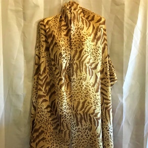 May include: A long, rectangular scarf with a brown and beige leopard and zebra print.