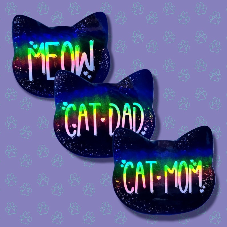 May include: Three black cat-shaped resin ornaments with a rainbow glitter finish. The ornaments read "MEOW", "CAT DAD", and "CAT MOM" in rainbow lettering.