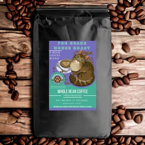 May include: A black bag of Toe Beans House Roast whole bean coffee, featuring a cartoon cat with green eyes and a purple background. The bag is labeled with the text "Toe Beans House Roast", "6 Bean Coffee Blend", "Whole Bean Coffee", "Fresh Roasted", "Net Weight: 12 oz (340g)", and "Ingredients: Coffee".