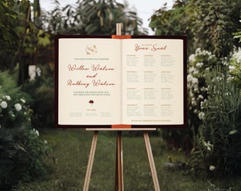 May include: An open book-style wedding seating chart on a wooden easel, set outdoors. The left page features the names "Willow Watson and Anthony Watson" in burgundy script. The right page lists guest names under "Your Seal".