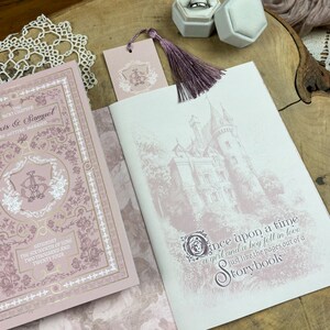 May include: A pink and gold wedding invitation with a floral design and a castle illustration. The text reads "The next chapter, Axis & Samuel, are getting married, Saturday, the sixteenth of June, two thousand and twenty four, Once upon a time, a girl and a boy fell in love, just like the pages out of a storybook."
