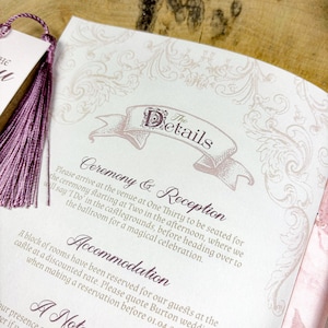 May include: A wedding invitation with a pink and white color scheme. The invitation features a decorative banner with the text "The Details" and information about the ceremony and reception. The invitation also includes details about accommodation.