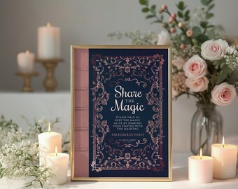 May include: A framed sign with the text "Share the Magic" in a decorative font. The sign has a navy blue background with rose gold floral accents and a pink spine. Candles and flowers surround the sign.