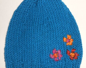 Bonnet en laine bleue décor fleuri.