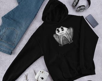 Puede incluir: Sudadera con capucha negra con un gráfico blanco de una rana de dibujos animados. La rana tiene una amplia sonrisa y ojos grandes.