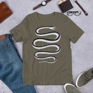 May include: A green t-shirt with a black and white snake design. The snake is coiled and has a stylized head with an open mouth.