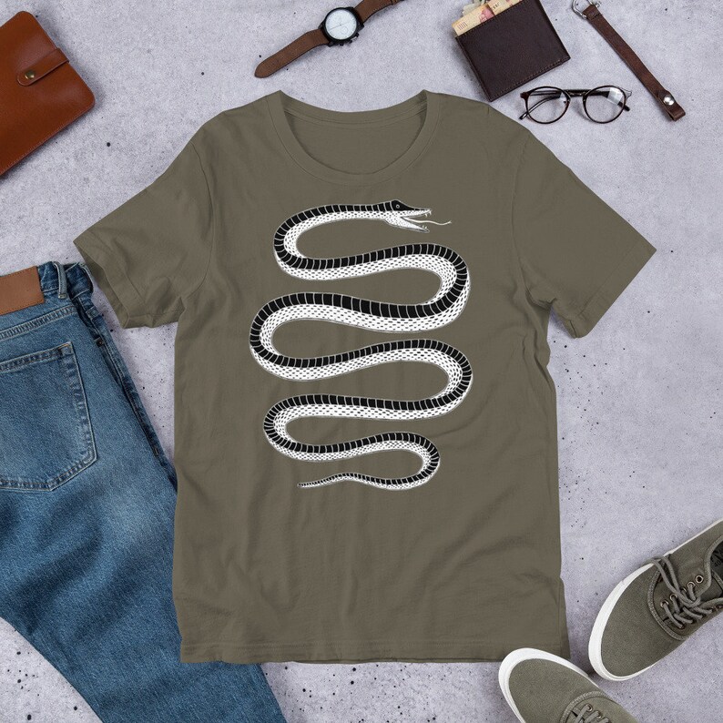 May include: A green t-shirt with a black and white snake design. The snake is coiled and has a stylized head with an open mouth.