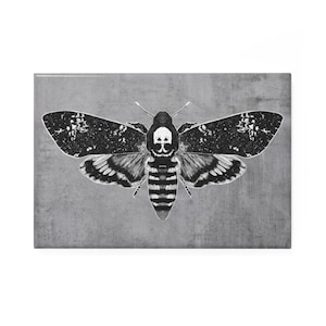 May include: Black and white illustration of a death's-head hawkmoth with a skull and crossbones pattern on its head. The moth is set against a gray textured background.