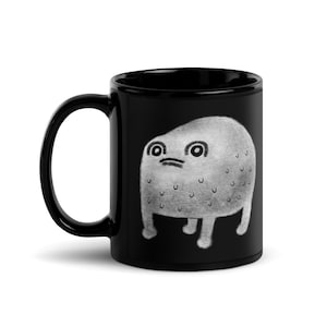 May include: Black coffee mug with a white illustration of a round, gray creature with large eyes and a textured surface. The creature has four short legs and is standing on a black background.