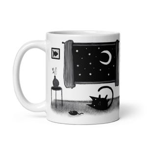 May include: White ceramic mug with a black and white illustration of a cat, a mouse, and a night sky with stars and a crescent moon. The illustration is on the front of the mug.