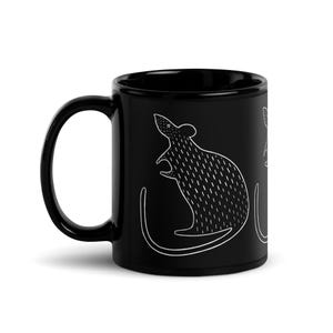 May include: A black ceramic mug featuring a white illustration of a stylized rat. The rat is depicted in a minimalist style with a long tail and detailed fur. The mug has a curved handle.
