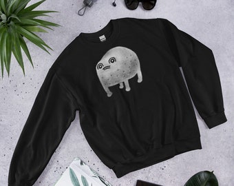 Puede incluir: Sudadera negra con un gráfico blanco de una criatura de dibujos animados con una expresión de sorpresa. La criatura tiene un cuerpo redondo, patas pequeñas y una cabeza grande con dos ojos y una boca.