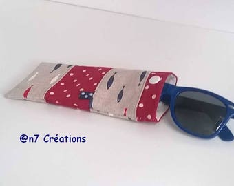 May include: A red, white, and beige fabric eyeglass case with a blue button closure. The case is decorated with a pattern of white fish and red polka dots. A pair of blue sunglasses is partially sticking out of the case.