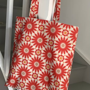 Tote bag à fleurs géométriques orange et jaune.