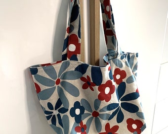 Bolso tote pequeño, con grandes flores azules y rojas.