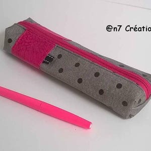 Grey school pencil case with black and pink polka dots.