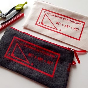 Op de afbeelding: Twee etui's met ritsen, met rode ritsen en rode afwerking. De etui's zijn gemaakt van verschillende materialen, een is van wit canvas en de andere van donkergrijs denim. Beide etui's hebben een rode afbeelding van een rechthoekige driehoek met de stelling van Pythagoras erop gedrukt. De tekst op de witte canvas etui is "CLE THEOREME DE PYTHAGORE: BC2 = AB2 + AC2". De tekst op de denim etui is "CLE THEOREME DE PYTHAGORE: BC2 = AB2 + AC2".