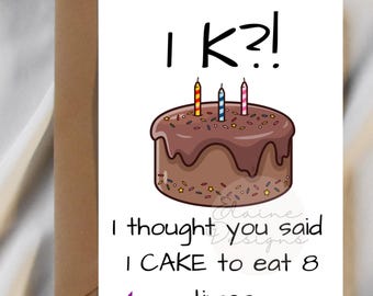 May include: A birthday card featuring a chocolate cake illustration with three candles and the text "I K?!" and "I thought you said I CAKE to eat 8 times." The card is on a brown envelope with a purple sticker that says "Free sticker with every purchase!"