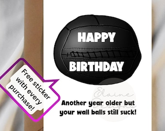 May include: A birthday card featuring a black volleyball design with the words "HAPPY BIRTHDAY" in white. The card also has the text "Another year older but your wall balls still suck!" and a sticker offer.