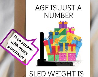 May include: A greeting card with the text "AGE IS JUST A NUMBER, SLED WEIGHT IS NOT" and a pile of colourful gift boxes. A sticker that says "Free sticker with every purchase!" is also included. The website elainelainedesigns.com is visible.
